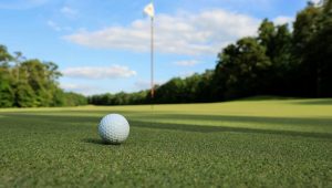 Golf ball on the putting green with the hole in the distance